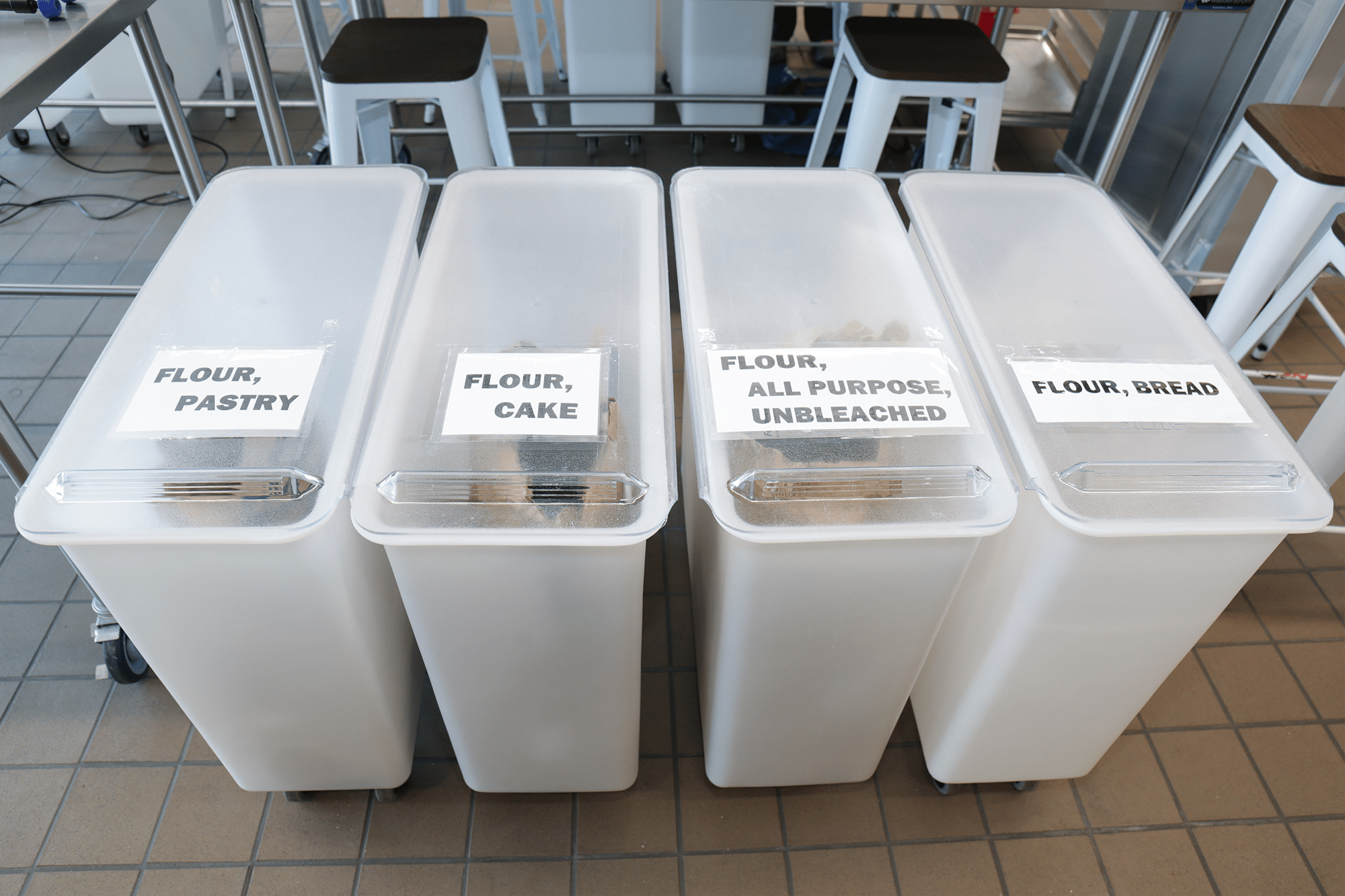 4 storage bins lined in a row with their contents printed on a label.
