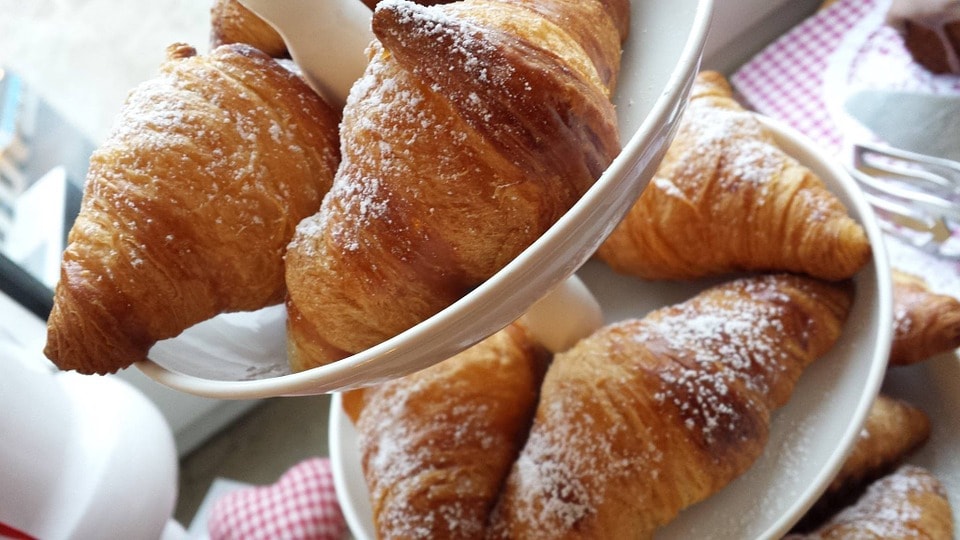 Golden brown croissant on a tiered service platter