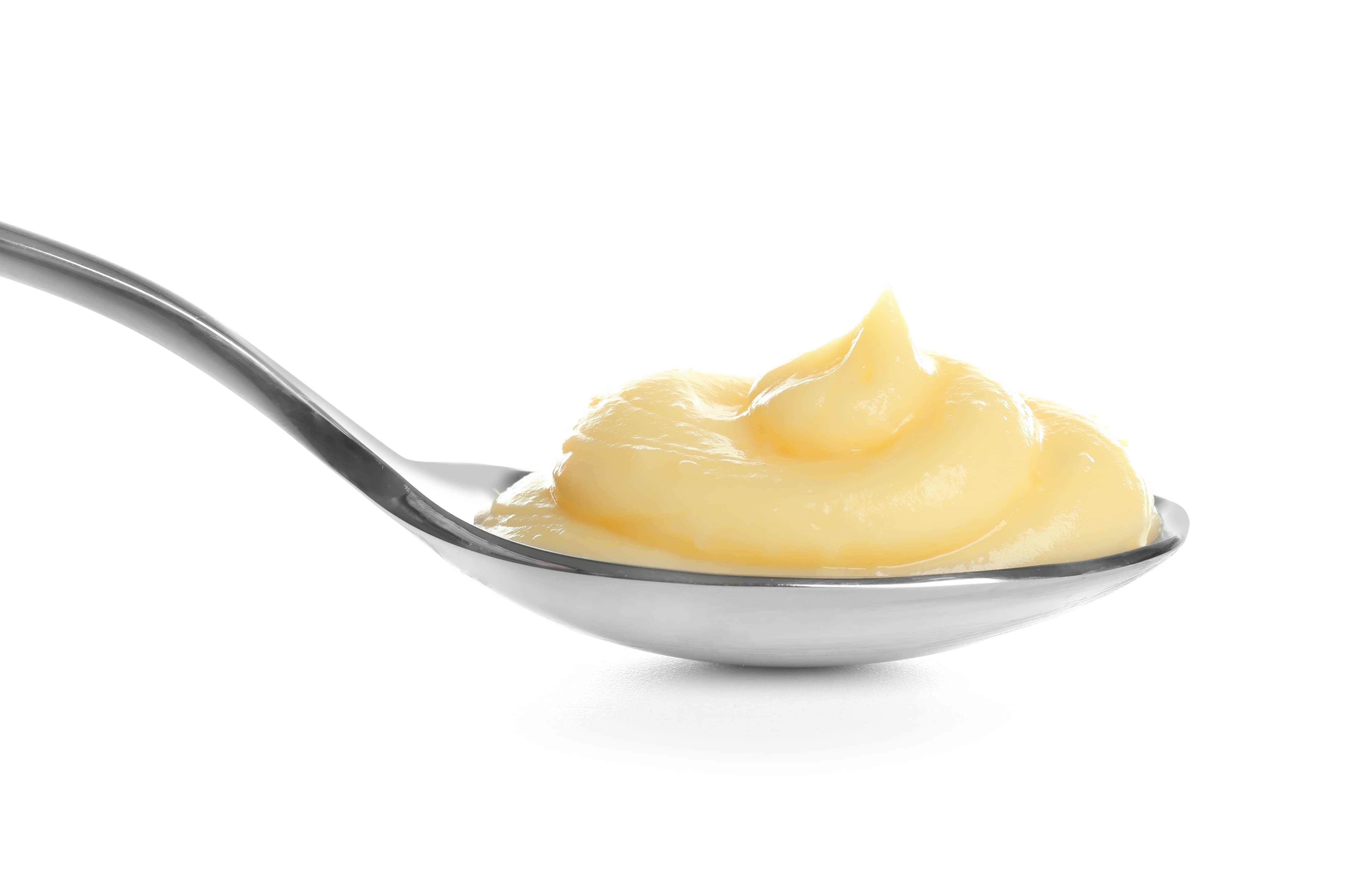 Vanilla pudding in spoon on white background.