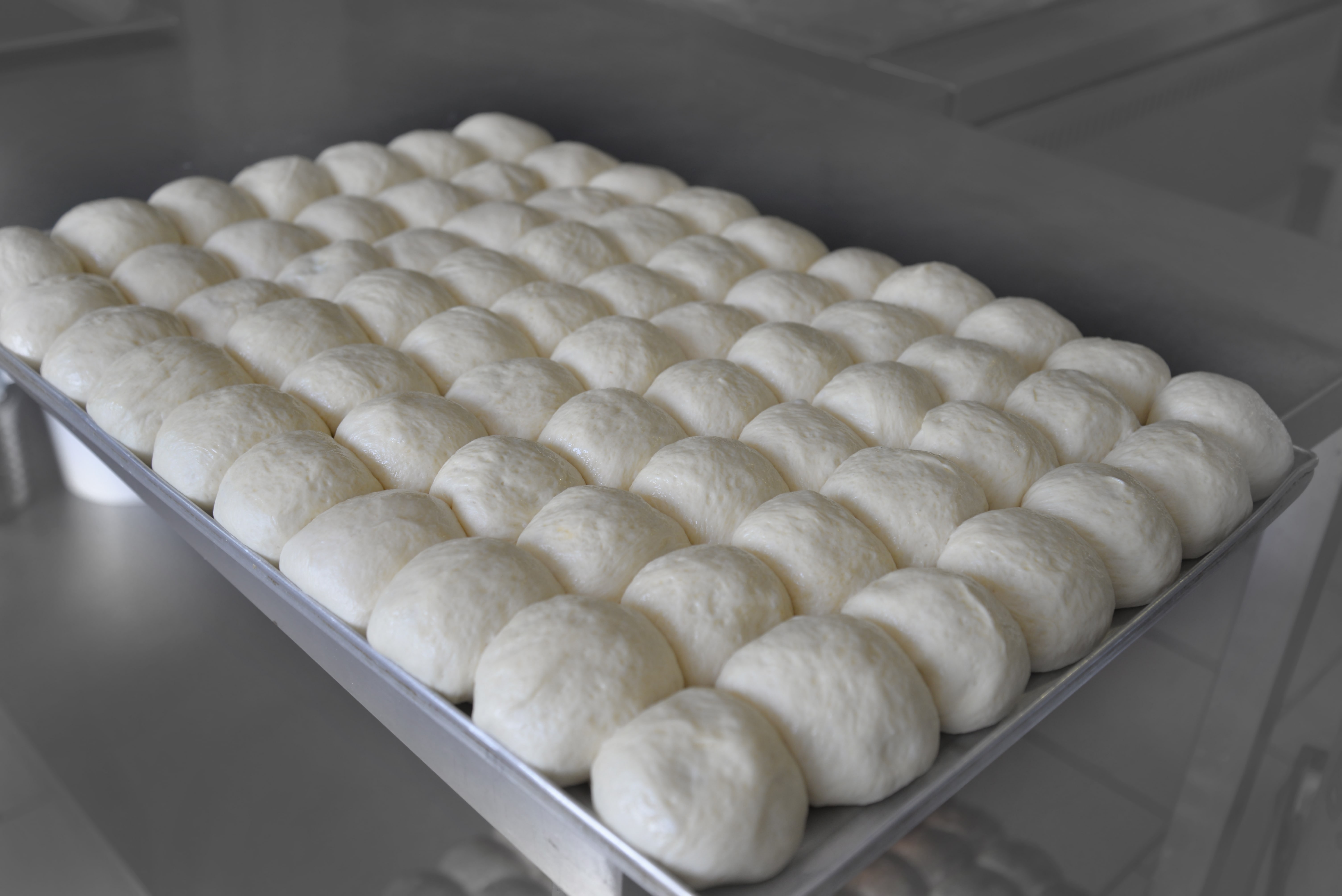 Baking from yeast dough. Metal baking tray with bread rolls.