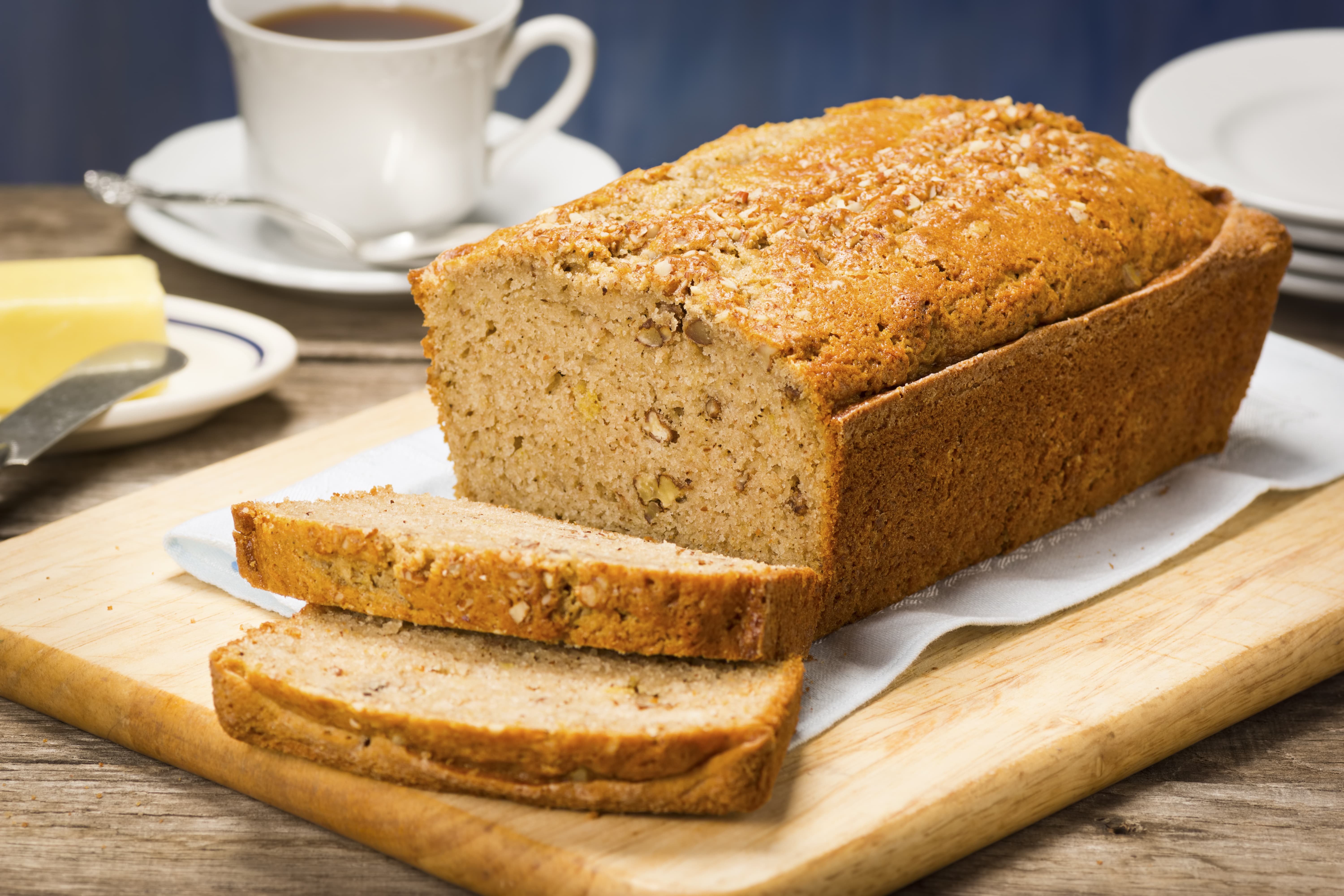 Banana Bread with Slices Cut Off the End on a Cutting Board.