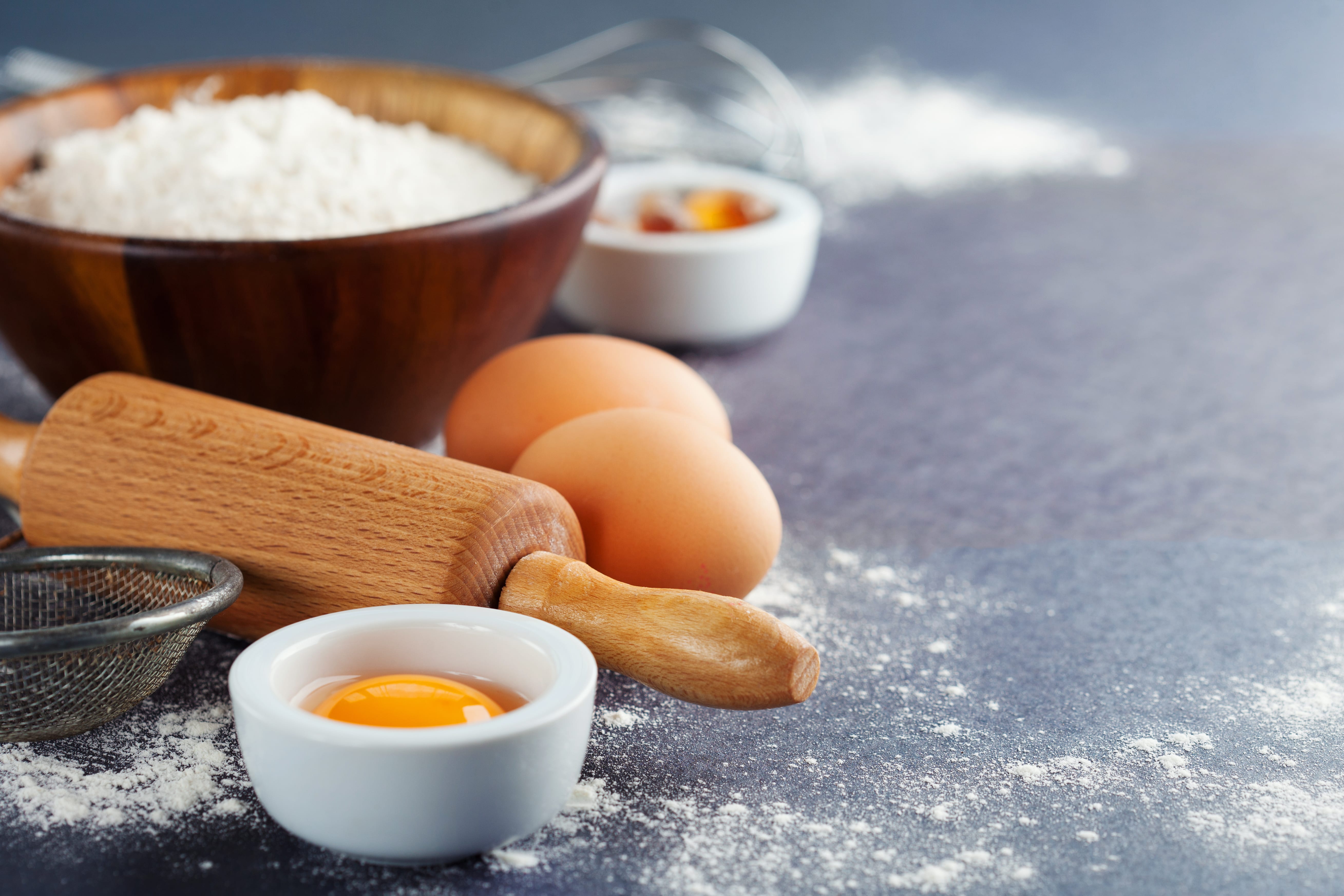 Ingredients and tools for baking - flour, eggs and rolling pin.