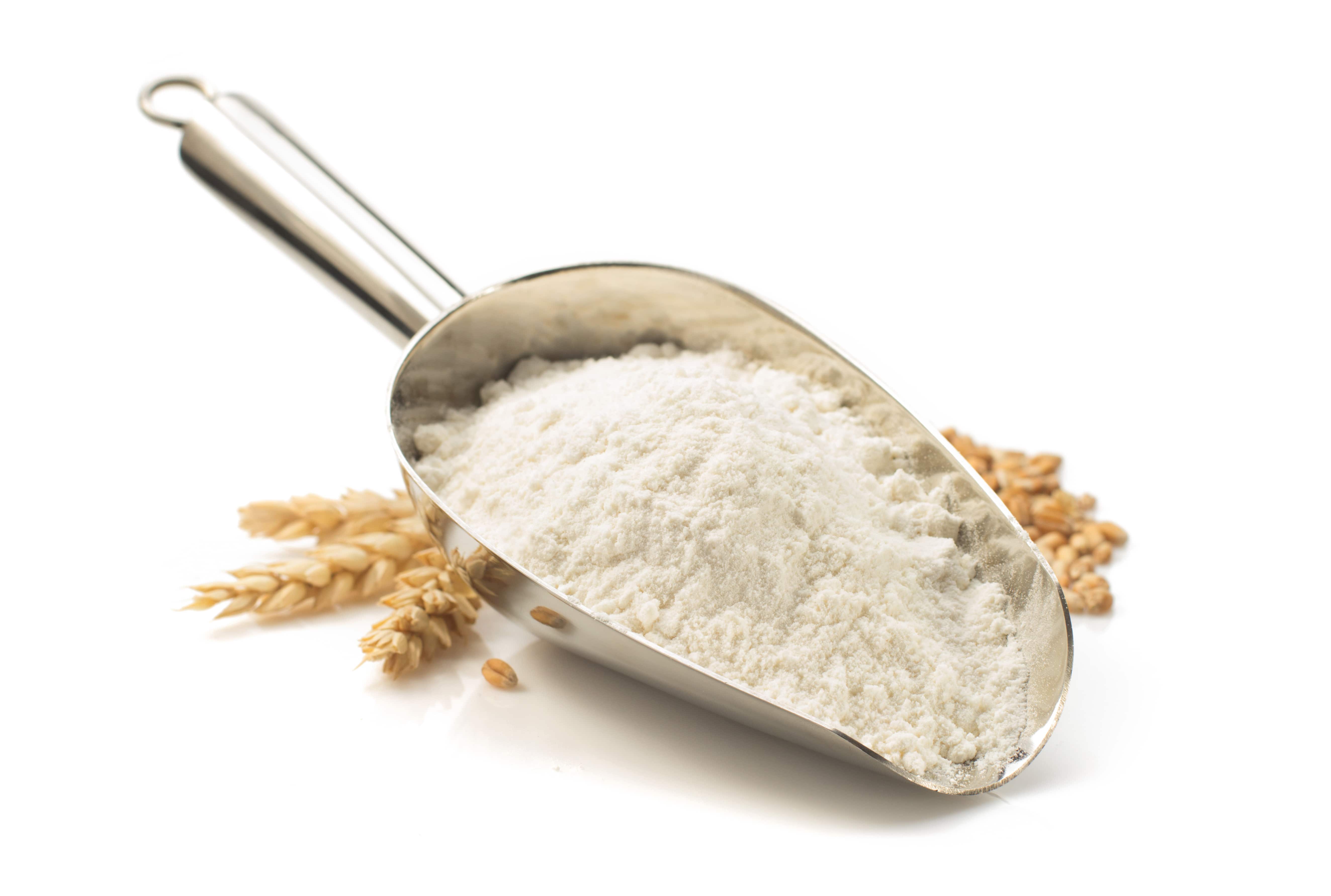 Wheat flour in flour spoon isolated on white background.