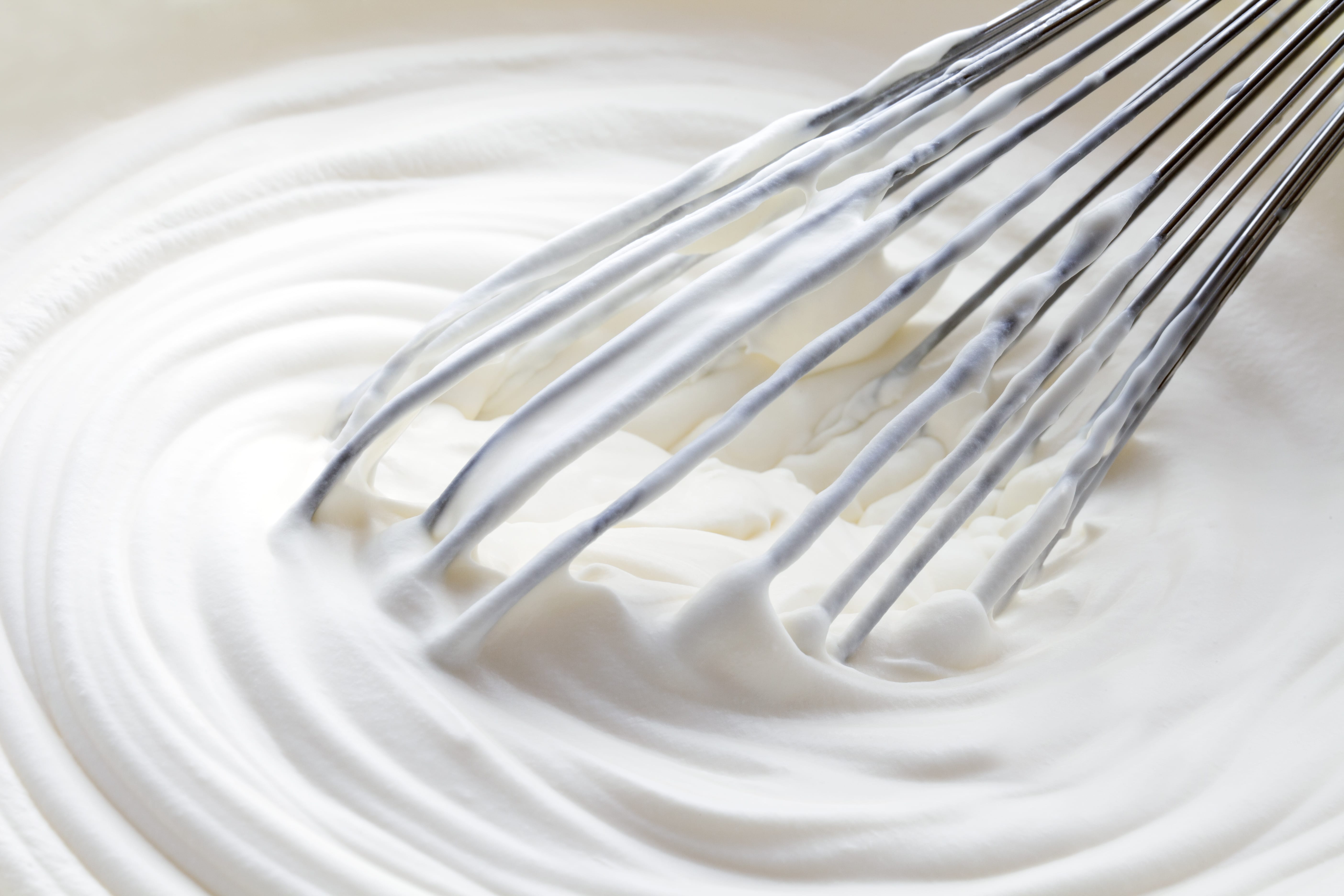 White whipped cream and electrical mixer
